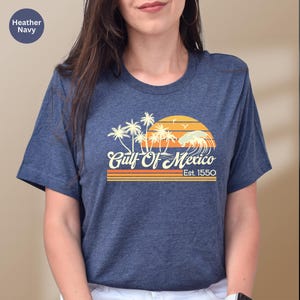 a woman wearing a blue shirt with palm trees on it