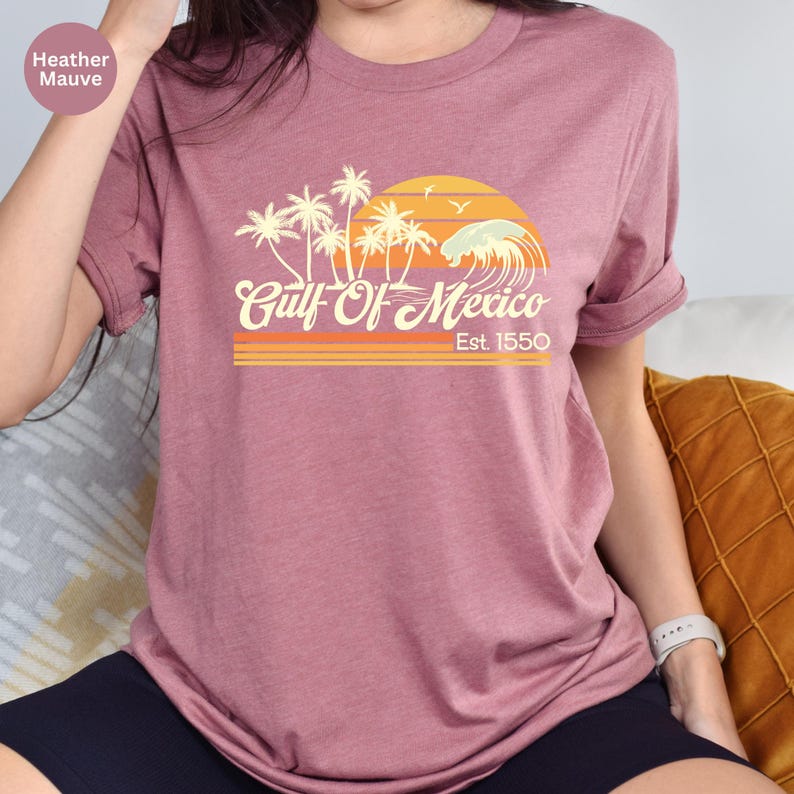 a woman sitting on a couch wearing a pink shirt