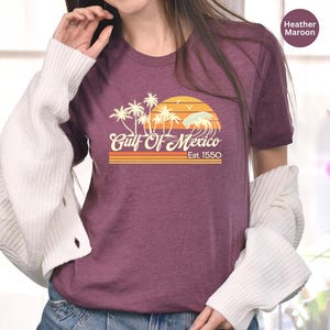 a woman wearing a shirt with palm trees on it