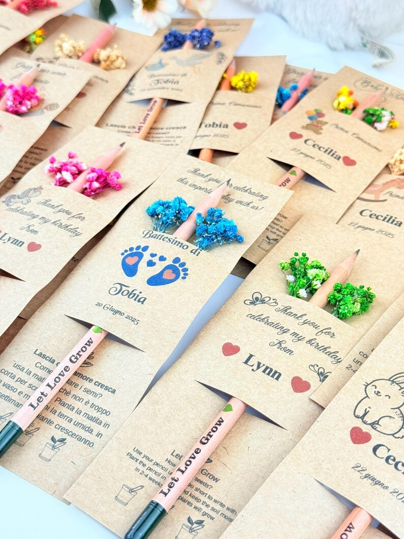 Puede incluir: Un conjunto de l&aacute;pices de semillas personalizados con adornos florales. Cada l&aacute;piz viene con una tarjeta con nombres, fechas y mensajes como "Thank you for celebrating my birthday". Los l&aacute;pices son de color rosa claro y tienen el texto "Let Love Grow."