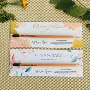 May include: Two wedding favor cards with a floral design and the text "Oliver & Claire" and "Let Love Grow". Each card has a wooden pencil with a black eraser and the text "Let Love Grow" printed on it. The cards include instructions on how to plant the pencil to grow a plant.