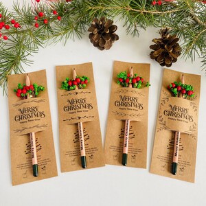 以下が含まれることがあります： 4つのクリスマスをテーマにしたギフトセット。各セットには、緑色の先端と「Merry Christmas」の文字が入った鉛筆、赤いベリーと緑の葉の小さな花束、そして「Merry Christmas Happy New Year」の文字が入ったクラフト紙のカードが含まれています。