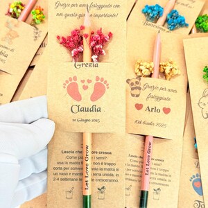 Puede incluir: L&aacute;pices de semillas personalizados con tarjetas. Las tarjetas color beige presentan texto e ilustraciones, incluyendo huellas de beb&eacute; y los nombres "Grezia" y "Arlo". Cada l&aacute;piz est&aacute; adornado con un peque&ntilde;o arreglo floral.