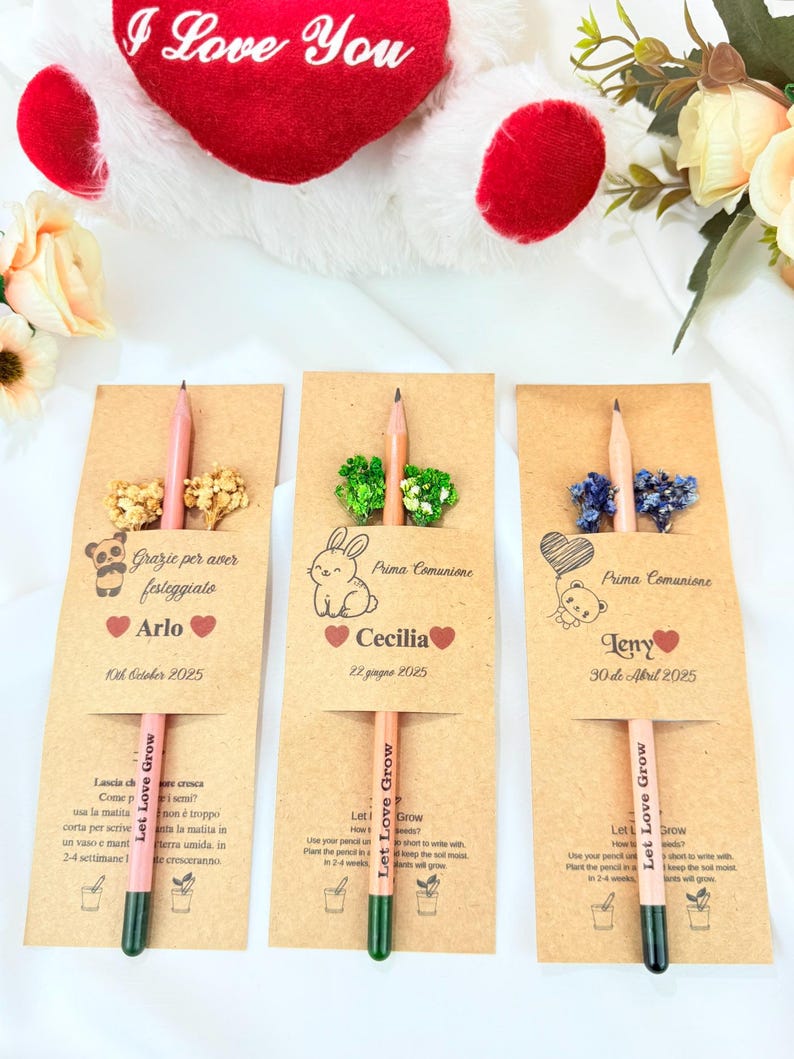 Puede incluir: Tres recuerdos de l&aacute;pices personalizados para la Primera Comuni&oacute;n, cada uno con un l&aacute;piz y adornos florales secos. Las tarjetas son de color marr&oacute;n claro con nombres y fechas, y los l&aacute;pices tienen el texto "Let Love Grow".