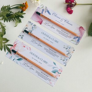 May include: Three wedding favor cards with floral designs and the text "Let Love Grow". Each card has a wooden pencil with seeds embedded in the tip. The cards are for Oliver & Claire's wedding on April 20, 2024.