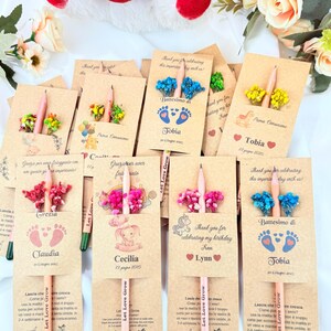 Puede incluir: Un conjunto de recuerdos personalizados para bautizos, primeras comuniones o cumplea&ntilde;os. Cada recuerdo incluye un l&aacute;piz con una semilla, una tarjeta decorativa y flores secas. Las tarjetas muestran nombres y fechas.