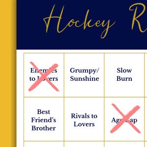 Puede incluir: Una tarjeta de bingo con el t&iacute;tulo "Hockey R" en escritura dorada sobre un fondo azul marino. La tarjeta presenta varios tropos rom&aacute;nticos, algunos marcados con una "X" rosa. El fondo es amarillo.