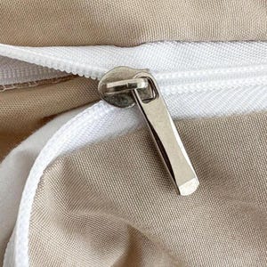 May include: Close-up of a beige fabric with a white zipper and a silver zipper pull. The zipper is partially open, revealing the white fabric underneath. The beige fabric has a subtle texture.
