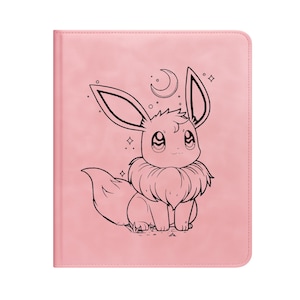 Peut inclure: Un carnet rose avec une illustration en noir et blanc d'un personnage de dessin animé. Le personnage a de grandes oreilles, un cou duveteux et un croissant de lune. Le carnet a une texture lisse semblable au cuir et une forme rectangulaire.