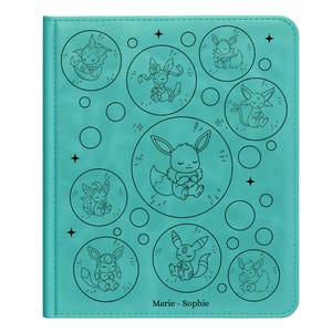 Könnte beinhalten: Türkisfarbener Kartenhalter mit schwarzen Strichzeichnungen von Cartoon-Charakteren in Kreisen. Die Hülle hat eine genähte Bordüre und den Text "Marie - Sophie" unten. Das Design umfasst Sterne und Kreise.