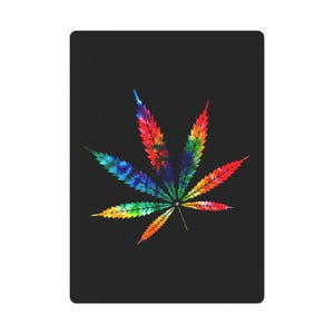 May include: A black rectangular item with a colourful tie-dye cannabis leaf design. The leaf is a mix of red, orange, yellow, green, blue, and purple, standing out against the dark background. The design is eye-catching and bold.