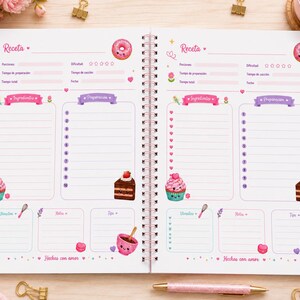 Puede incluir: Un cuaderno de recetas con encuadernaci&oacute;n en espiral que muestra dos p&aacute;ginas id&eacute;nticas con detalles en rosa y morado. Cada p&aacute;gina incluye secciones para el nombre de la receta, porciones, tiempo, ingredientes y pasos de preparaci&oacute;n, decoradas con ilustraciones de donas, cupcakes y pastel.