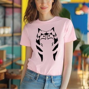 a woman wearing a pink shirt with a black cat on it