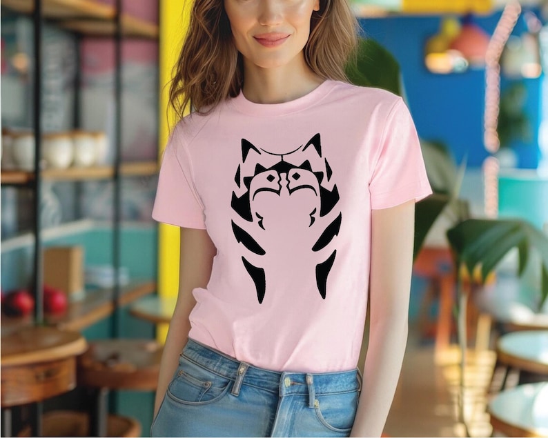 a woman wearing a pink shirt with a black cat on it