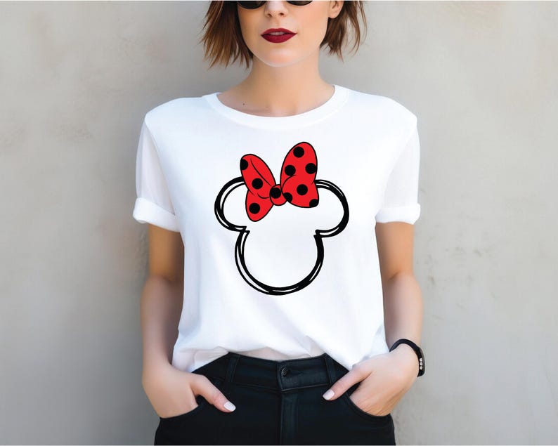 a woman wearing a white shirt with a red minnie mouse head on it