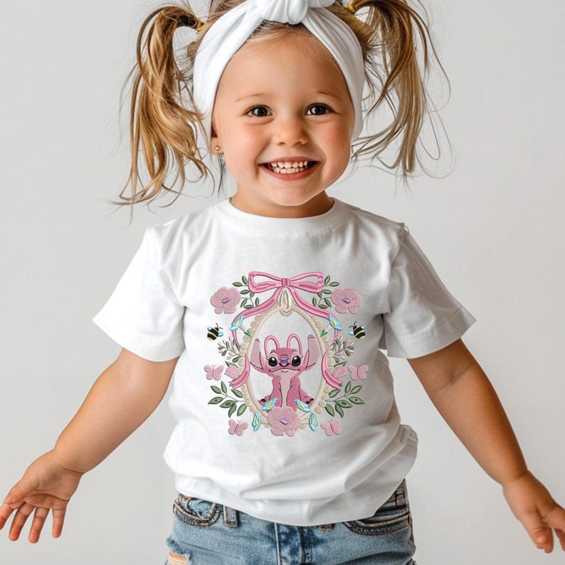 a little girl wearing a white t - shirt with an elephant on it