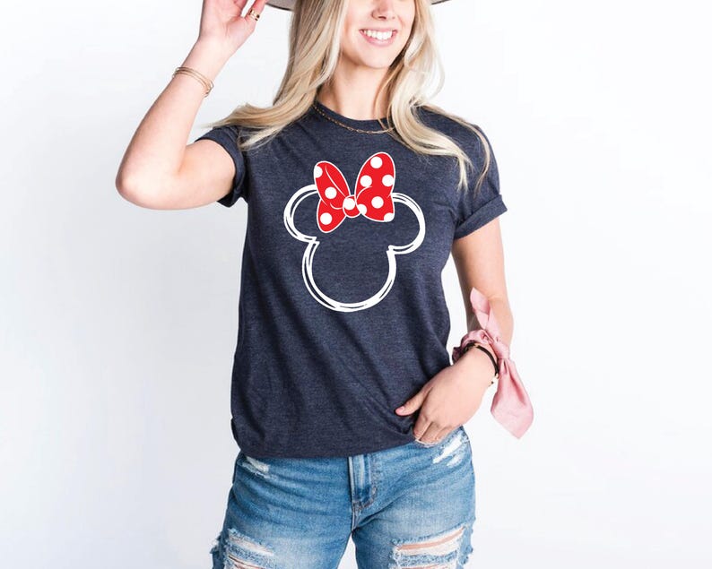 a woman wearing a mickey mouse shirt and a hat