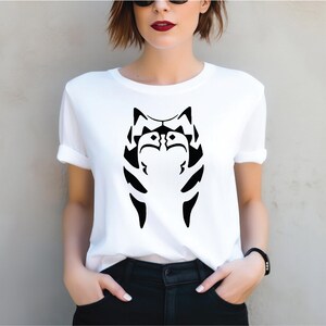 a woman wearing a white shirt with a black cat on it