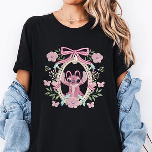 a woman wearing a black shirt with a pink bunny on it