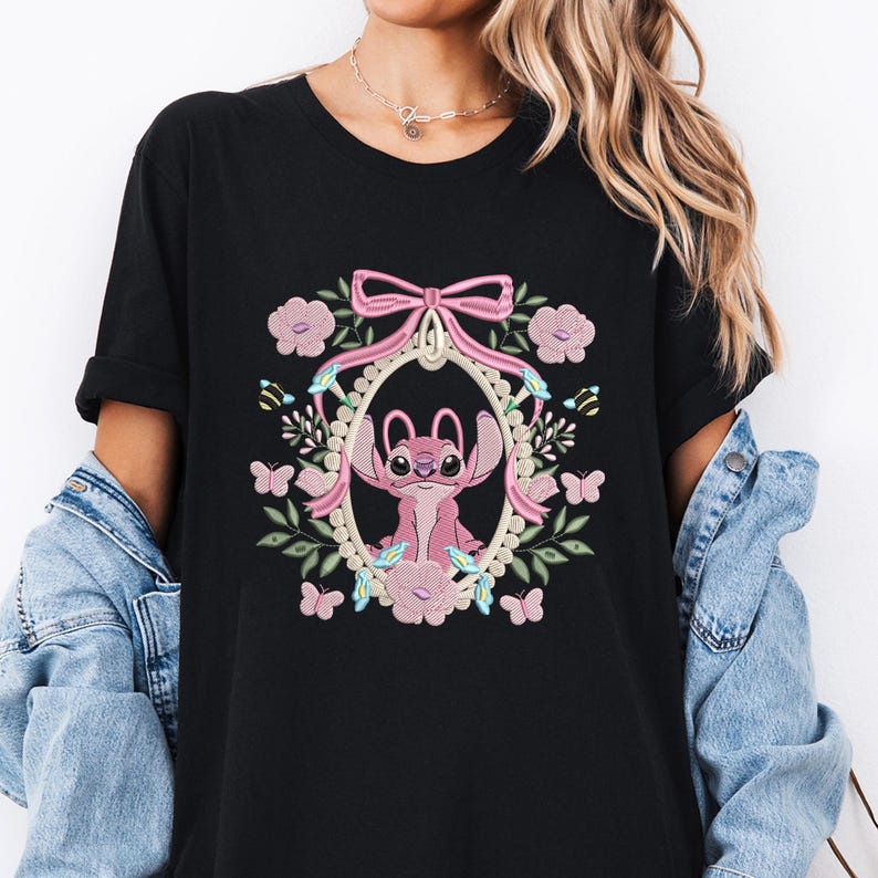 a woman wearing a black shirt with a pink bunny on it