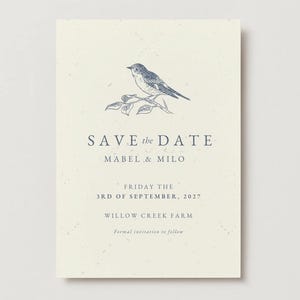 Może przedstawiać: Kremowa karta save-the-date z szczegółową ilustracją ptaka na gałęzi. Tekst brzmi "SAVE the DATE", a następnie imiona, data i miejsce. Formalne zaproszenie.