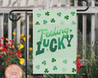 Może przedstawiać: Zielono-biała flaga ogrodowa z wzorem koniczyny i tekstem "Feeling Lucky".