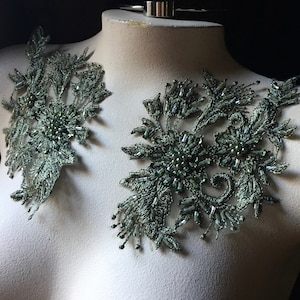 Puede incluir: Dos apliques florales de cuentas verdes con un delicado diseño de encaje. Los apliques son perfectos para agregar un toque de elegancia a cualquier prenda.