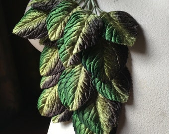 May include: A bunch of green and brown velvet leaves, perfect for crafting or decorating.