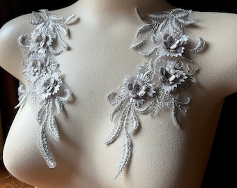 May include: Two silver floral appliques with white flowers and leaves. The appliques are on a white mannequin bust.