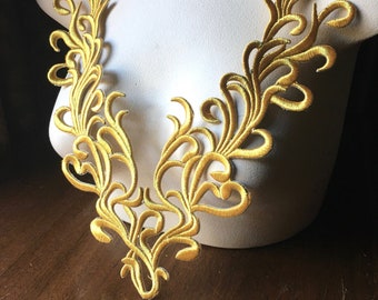 May include: Gold embroidered lace trim featuring a delicate floral design. This trim is ideal for adding a touch of elegance to any project.