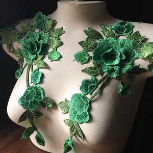 Pode incluir: Dois apliques florais verdes com efeito 3D. Os apliques são feitos de renda e apresentam uma flor grande com flores e folhas menores.