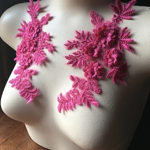 May include: Two pink floral lace appliques, perfect for adding a touch of elegance to clothing or crafts.