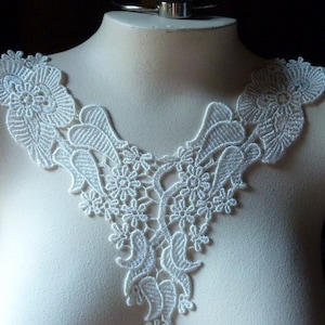 Op de afbeelding: Witte kantversiering met een bloemen- en paisleymotief. De versiering is perfect om een ​​toets van elegantie aan elk project toe te voegen.