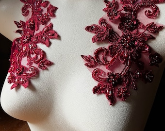 May include: Two burgundy lace appliques with beaded embellishments, perfect for adding a touch of elegance to a garment.