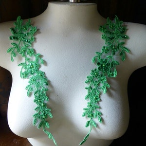 May include: Two green lace appliques with beaded flowers, ideal for adding a touch of elegance to a garment or craft project.