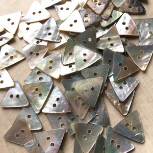 May include: A large pile of iridescent, triangular, mother-of-pearl buttons with two holes each.