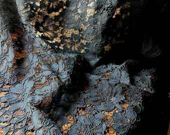 Puede incluir: Tela de encaje negro con un patrón floral. El encaje es delicado e intrincado, con una textura suave y fluida.