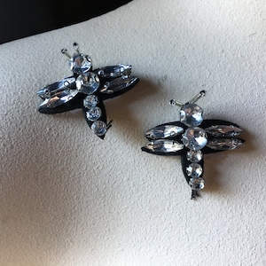May include: Two black fabric dragonfly embellishments with clear rhinestone accents.