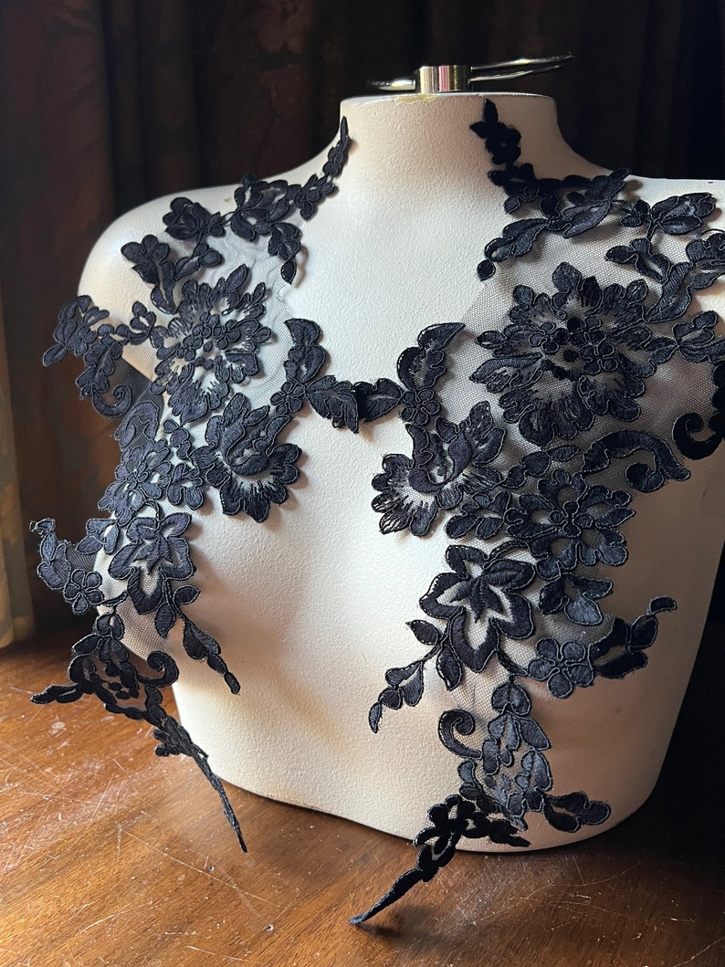 May include: Black floral lace applique with delicate details. This lace trim is perfect for adding a touch of elegance to any project.