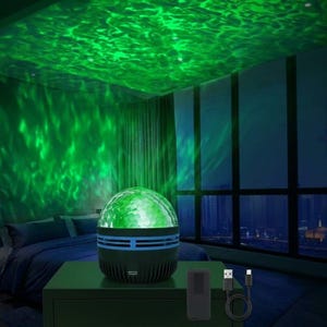 May include: A black spherical light projector with a textured glass dome that emits a vibrant green rippling water effect onto the ceiling and walls. The device features a cylindrical base with horizontal vents and includes a black remote control and a USB cable.