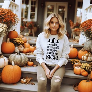 May include: A white sweatshirt with a black graphic print of three witch hats and the text "Another Glorious Morning. Makes Me Sick!"