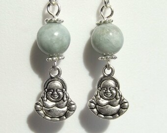 May include: Silver earrings with a light green jade stone and a silver charm of a smiling Buddha.