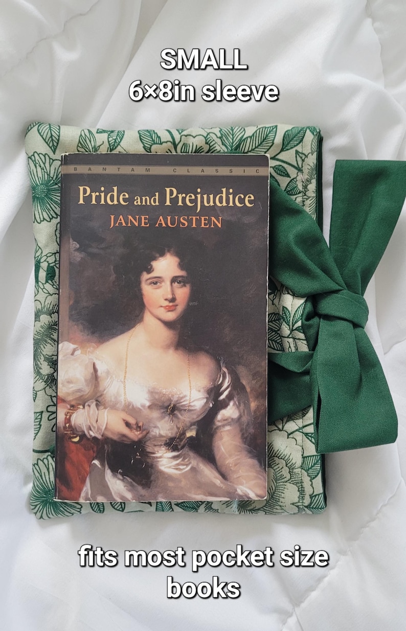 May include: A small, green floral book sleeve, 6x8 inches, with a copy of "Pride and Prejudice" by Jane Austen. The book is nestled inside the sleeve, with a matching green tie. The text "fits most pocket size books" is also visible.