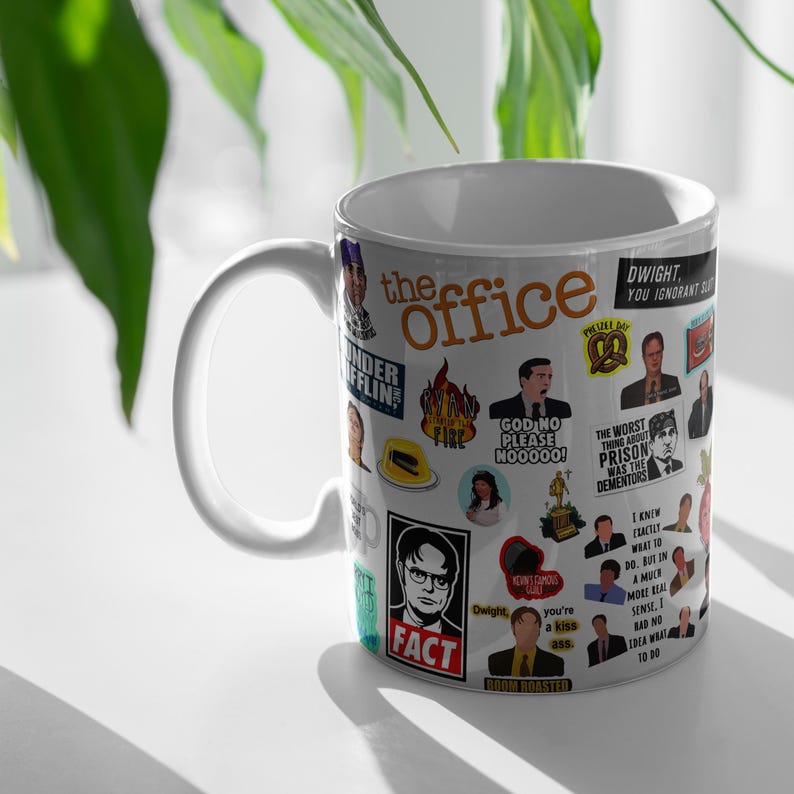 May include: White ceramic mug with a colourful design featuring characters and quotes from the TV show "The Office".
