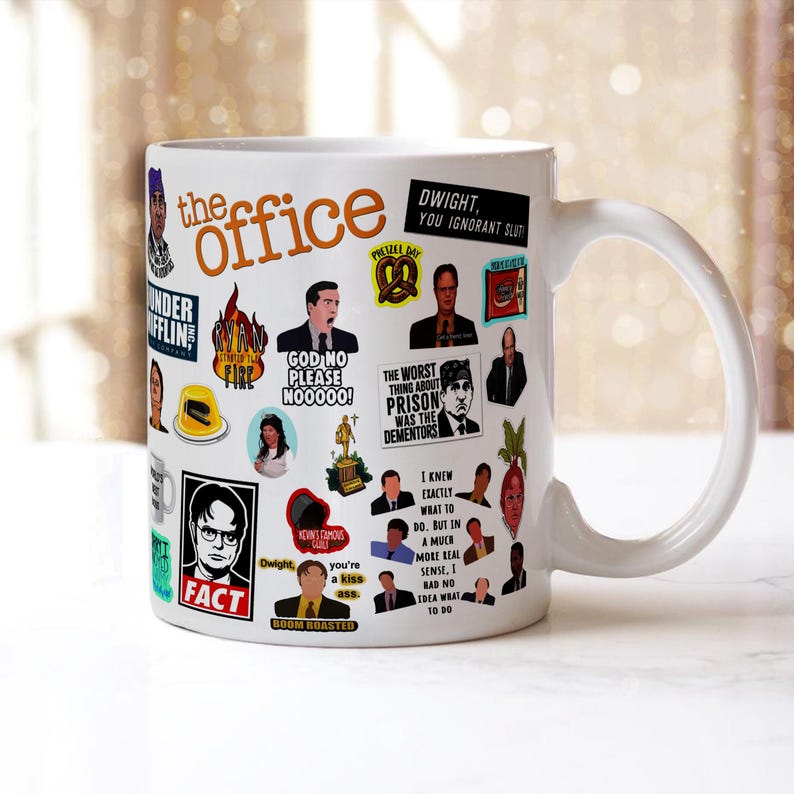 May include: White ceramic mug with a colourful design featuring characters and quotes from the TV show "The Office". The mug has a black handle and the words "the office" are printed in orange.