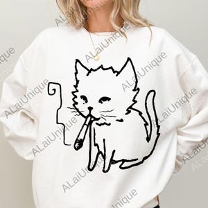 May include: White sweatshirt featuring a black line drawing of a cat smoking a cigarette. The cat is sitting upright with a relaxed expression. The sweatshirt has the text "ALaiUnique" repeated around the image.