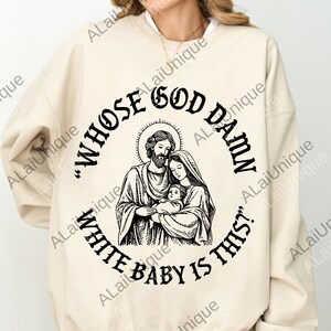 May include: A cream-coloured sweatshirt with a black graphic. The graphic shows a religious family image with the text "WHOSE GOD DAMN WHITE BABY IS THIS?" in a circular design around the image.
