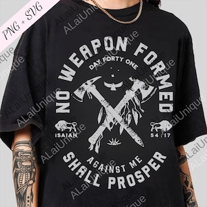 May include: Black t-shirt with a white graphic design featuring crossed axes, a bird, and the text "NO WEAPON FORMED AGAINST ME SHALL PROSPER." The design also includes the text "Isaiah 54:17" and a buffalo illustration.