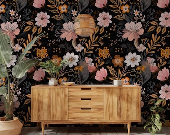May include: A wooden dresser with three drawers sits in front of a black background with a floral pattern. The flowers are pink, white, and yellow with gold accents.