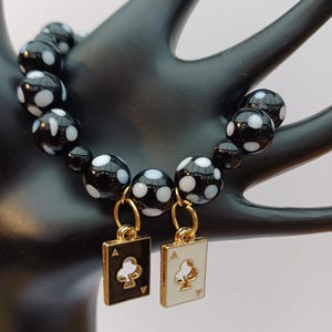 Speel je kaarten goed. Prachtige zwart-witte pokerspelerarmband met zwart-witte gevlekte glaskralen en klaveren bedel